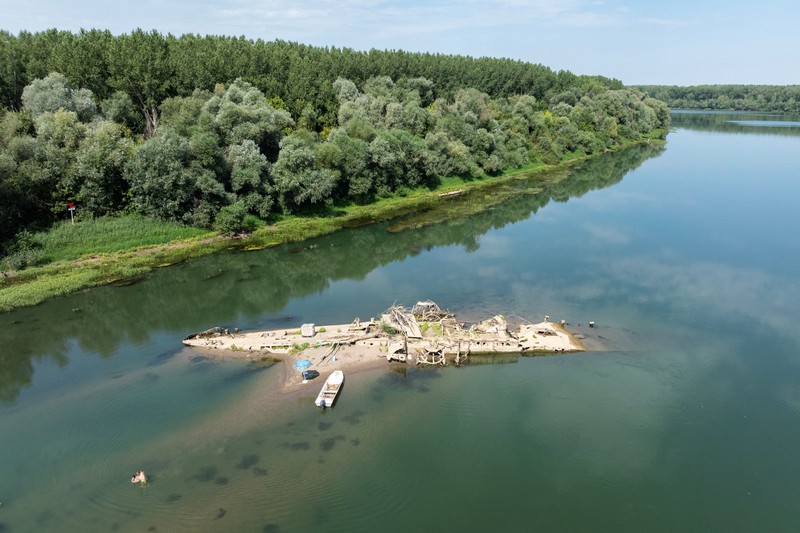 Bangkai kapal tunda Slovenac&mdash;yang tenggelam setelah menabrak ranjau pada tahun 1945&mdash;di Sungai Sava terlihat saat permukaan air turun akibat cuaca panas berkepanjangan dan kondisi kering, di dekat Sremska Mitrovica, Serbia, 12 Agustus 2026. (REUTERS/Marko Djurica)