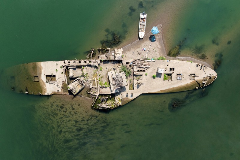 Bangkai kapal tunda Slovenac&mdash;yang tenggelam setelah menabrak ranjau pada tahun 1945&mdash;di Sungai Sava terlihat saat permukaan air turun akibat cuaca panas berkepanjangan dan kondisi kering, di dekat Sremska Mitrovica, Serbia, 12 Agustus 2026. (REUTERS/Marko Djurica)