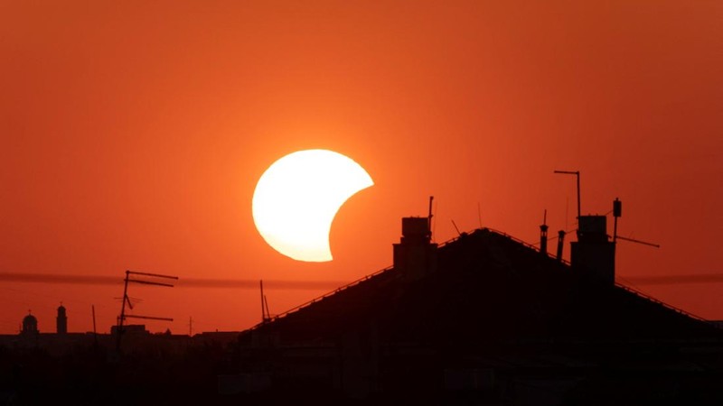 Bulan menutupi sebagian Matahari di atas sebuah atap saat gerhana matahari, sebagaimana terlihat dari Beograd, Serbia, pada 12 Agustus 2026.