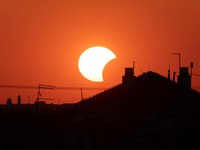 Bulan menutupi sebagian Matahari di atas sebuah atap saat gerhana matahari, sebagaimana terlihat dari Beograd, Serbia, pada 12 Agustus 2026. (REUTERS/Djordje Kojadinovic)