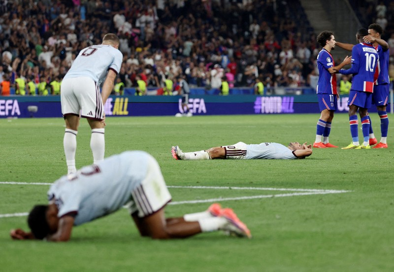 Pemain Paris Saint-Germain Marquinhos mengangkat trofi bersama rekan-rekannya setelah memenangkan Piala Super UEFA di Stadion Salzburg, Salzburg, Austria, 12 Agustus 2026.  (REUTERS/Angelika Warmuth)