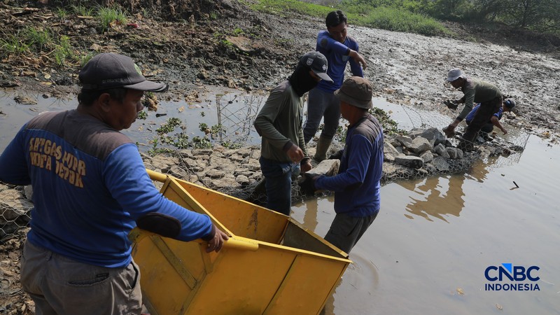 Petugas Satgas SDA PUPR kota depok memasang bronjong batu kali di lokasi bekas banjir yang kini sudah mengering di Jalan penghubung Kampung Bulak, Cipayung, Depok, Jawa Barat, Kamis, (13/8/2026). (CNBC Indonesia/Muhammad Sabki)