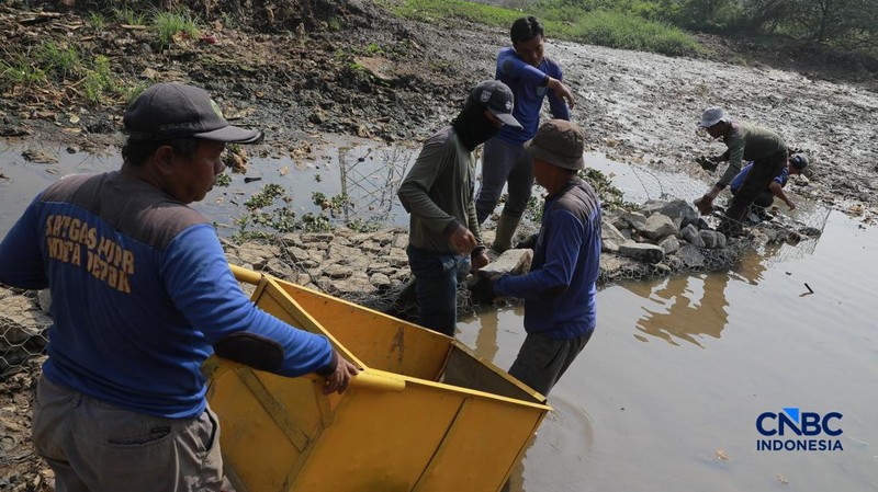 Petugas Satgas SDA PUPR kota depok memasang bronjong batu kali di lokasi bekas banjir yang kini sudah mengering di Jalan penghubung Kampung Bulak, Cipayung, Depok, Jawa Barat, Kamis, (13/8/2026).