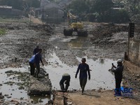 Petugas Satgas SDA PUPR kota depok memasang bronjong batu kali di lokasi bekas banjir yang kini sudah mengering di Jalan penghubung Kampung Bulak, Cipayung, Depok, Jawa Barat, Kamis, (13/8/2026). (CNBC Indonesia/Muhammad Sabki)