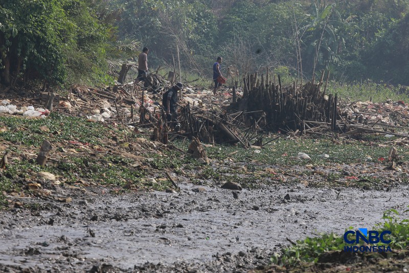 Petugas Satgas SDA PUPR kota depok memasang bronjong batu kali di lokasi bekas banjir yang kini sudah mengering di Jalan penghubung Kampung Bulak, Cipayung, Depok, Jawa Barat, Kamis, (13/8/2026). (CNBC Indonesia/Muhammad Sabki)