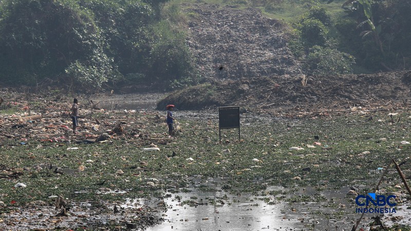 Petugas Satgas SDA PUPR kota depok memasang bronjong batu kali di lokasi bekas banjir yang kini sudah mengering di Jalan penghubung Kampung Bulak, Cipayung, Depok, Jawa Barat, Kamis, (13/8/2026). (CNBC Indonesia/Muhammad Sabki)