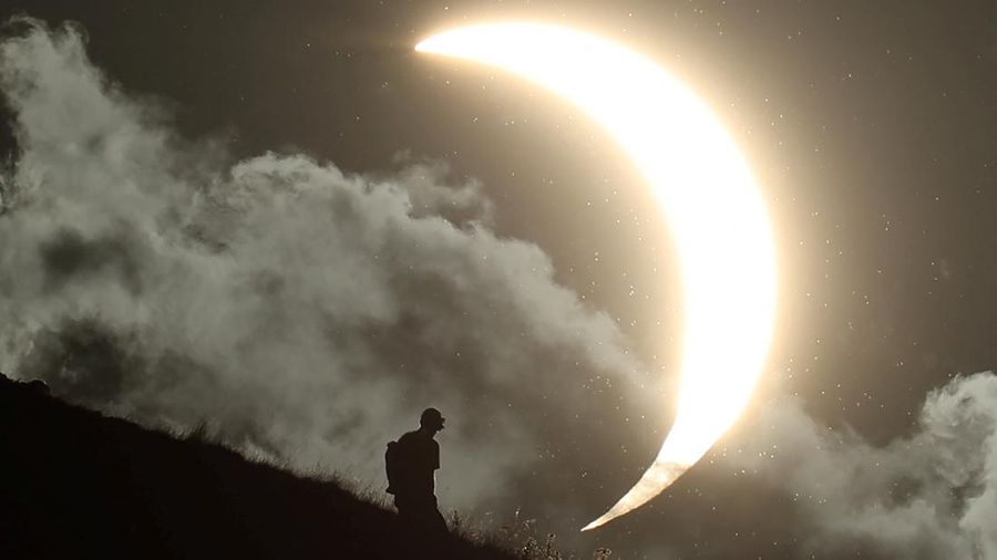 Seseorang menyaksikan gerhana matahari sebagian di Glastonbury Tor, Glastonbury, Inggris, pada 12 Agustus 2026.