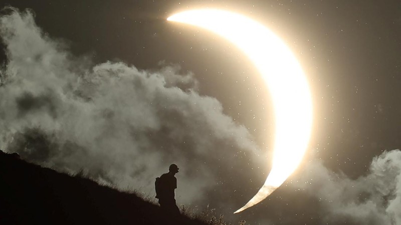 Seseorang menyaksikan gerhana matahari sebagian di Glastonbury Tor, Glastonbury, Inggris, pada 12 Agustus 2026.