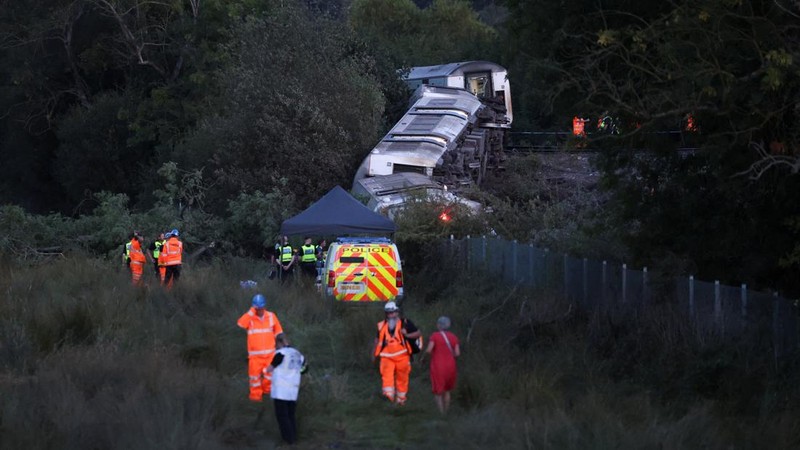 Petugas darurat bekerja di lokasi kejadian di samping kereta yang terguling setelah kereta penumpang layanan Southern tergelincir di dekat Lewes, Inggris tenggara, Kamis (13/8/2026). (REUTERS/Toby Shepheard)
