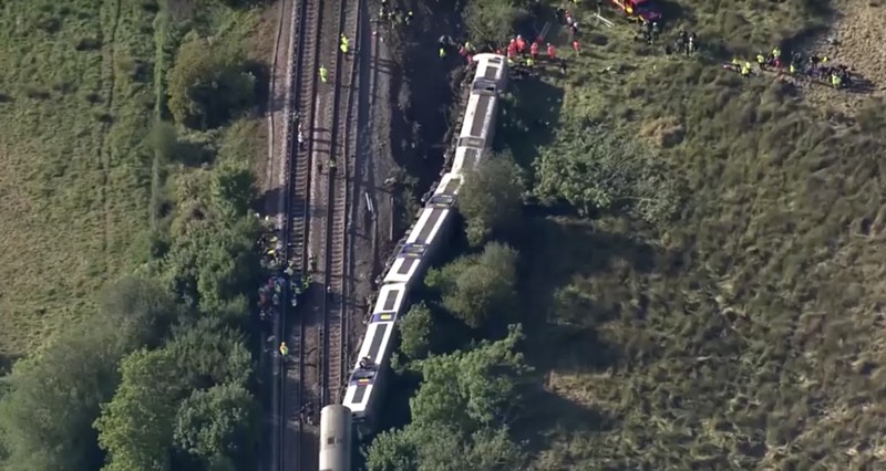 Petugas darurat bekerja di lokasi kejadian di samping kereta yang terguling setelah kereta penumpang layanan Southern tergelincir di dekat Lewes, Inggris tenggara, Kamis (13/8/2026). (REUTERS/Toby Shepheard)