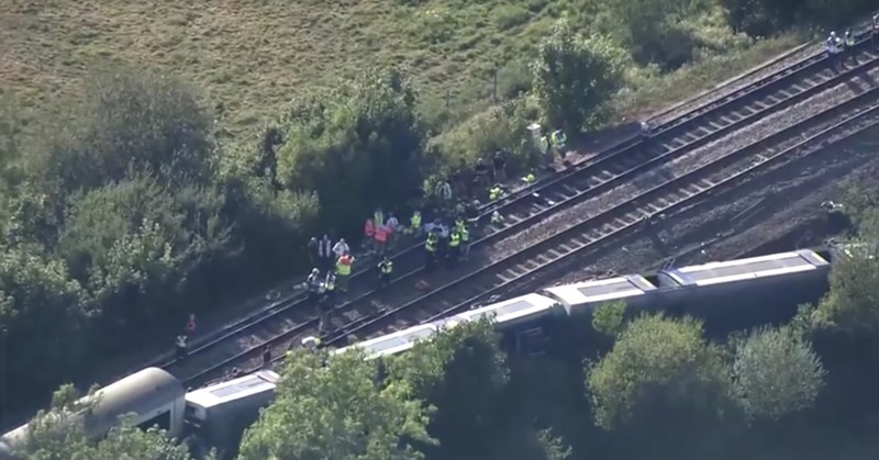 Petugas darurat bekerja di lokasi kejadian di samping kereta yang terguling setelah kereta penumpang layanan Southern tergelincir di dekat Lewes, Inggris tenggara, Kamis (13/8/2026). (REUTERS/Toby Shepheard)