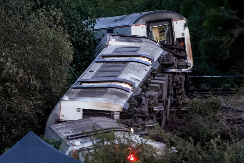 Petugas darurat bekerja di lokasi kejadian di samping kereta yang terguling setelah kereta penumpang layanan Southern tergelincir di dekat Lewes, Inggris tenggara, Kamis (13/8/2026). (REUTERS/Toby Shepheard)