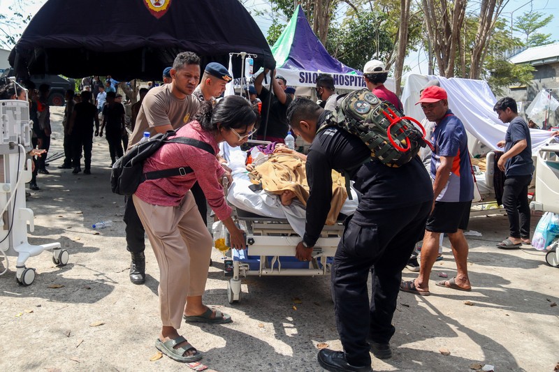 Warga desa duduk di bawah tenda darurat setelah mengungsi ke perbukitan menyusul gempa bumi yang terasa di Sikka, Indonesia, Minggu (16/8/2026). (REUTERS/Stringer)