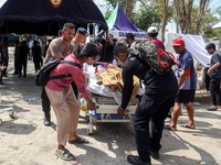 Petugas kepolisian membantu memindahkan seorang pasien ke tempat penampungan di area terbuka sebuah rumah sakit, menyusul gempa bumi yang terasa di Labuan Bajo, Provinsi Nusa Tenggara Timur, Indonesia, Minggu (15/8/2026). (REUTERS/Stringer)