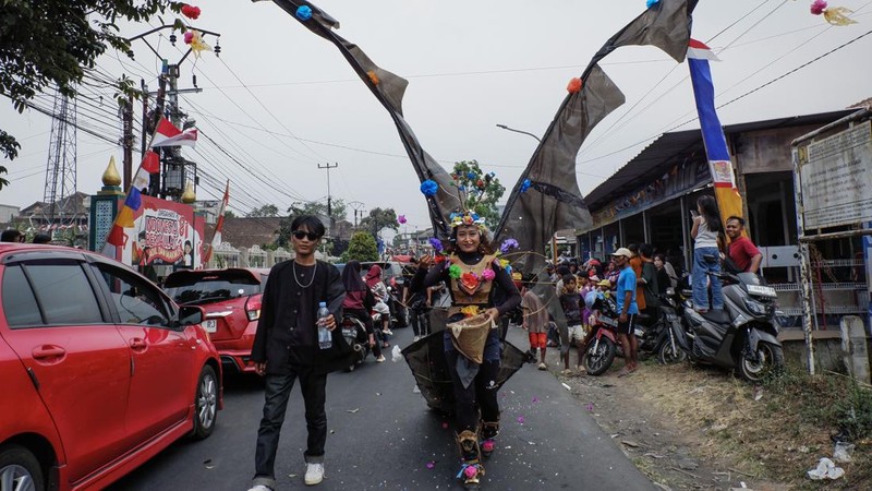 Warga yang mengenakan kostum kreasi berpartisipasi dalam karnaval budaya jalanan untuk merayakan HUT ke-81 Kemerdekaan Indonesia di Bayongbong, Garut, Jawa Barat, Minggu (16/8/2026). (ZUMA Press Wire via Reuters Conn)