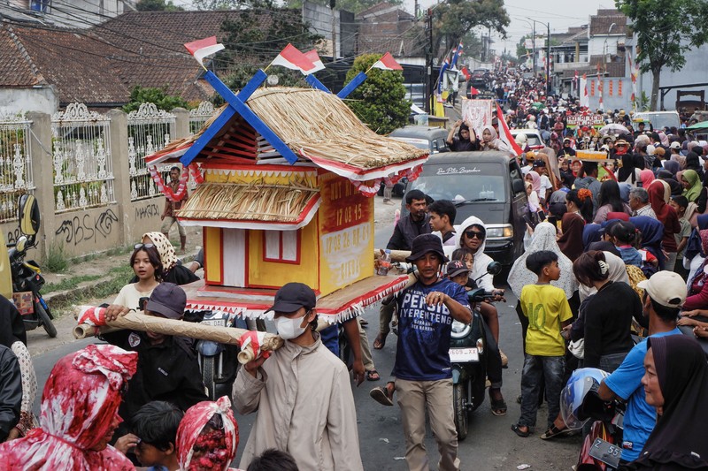 Warga yang mengenakan kostum kreasi berpartisipasi dalam karnaval budaya jalanan untuk merayakan HUT ke-81 Kemerdekaan Indonesia di Bayongbong, Garut, Jawa Barat, Minggu (16/8/2026). (ZUMA Press Wire via Reuters Conn)