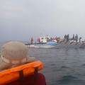 Rescue workers and local boat operators take part in ongoing search and recovery operations near the overturned passenger ferry on Lake Kariba, a day after the vessel capsized, in Kariba, Zimbabwe, August 12, 2026. REUTERS/Admore Mbonda PICTURE TAKEN