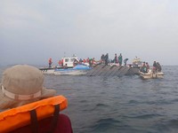 Rescue workers and local boat operators take part in ongoing search and recovery operations near the overturned passenger ferry on Lake Kariba, a day after the vessel capsized, in Kariba, Zimbabwe, August 12, 2026. REUTERS/Admore Mbonda PICTURE TAKEN