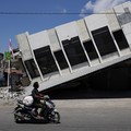 Seorang pria mengendarai motor melintasi sebuah swalayan yang runtuh akibat gempa bumi di Reok, Provinsi Nusa Tenggara Timur, Indonesia, 18 Agustus 2026. REUTERS/Willy Kurniawan