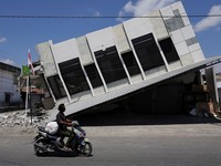 Seorang pria mengendarai motor melintasi sebuah swalayan yang runtuh akibat gempa bumi di Reok, Provinsi Nusa Tenggara Timur, Indonesia, 18 Agustus 2026. REUTERS/Willy Kurniawan