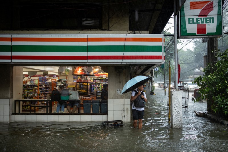 Warga menerjang banjir saat hujan deras musim monsun di Kota Manila, Filipina, Senin (17/8/2026). (REUTERS/Eloisa Lopez)