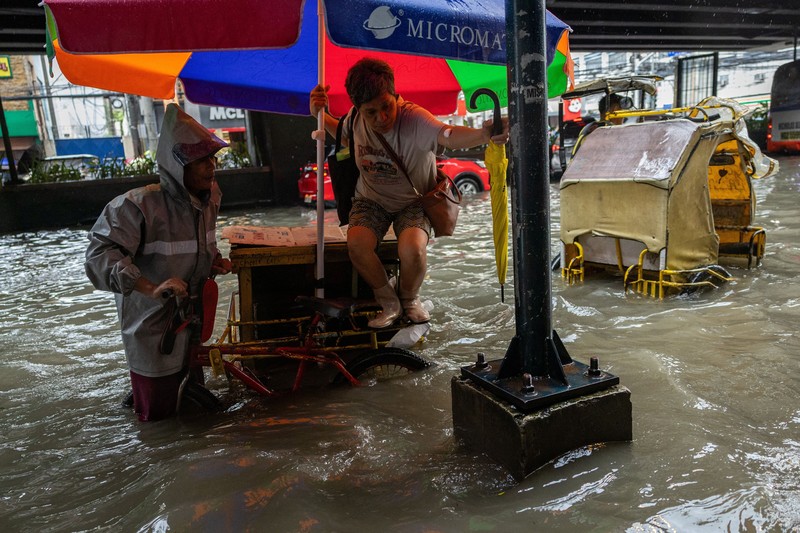 Warga menerjang banjir saat hujan deras musim monsun di Kota Manila, Filipina, Senin (17/8/2026). (REUTERS/Eloisa Lopez)