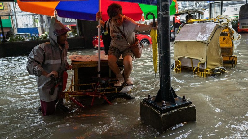 Warga menerjang banjir saat hujan deras musim monsun di Kota Manila, Filipina, Senin (17/8/2026). (REUTERS/Eloisa Lopez)