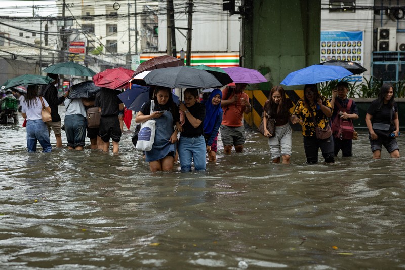 Warga menerjang banjir saat hujan deras musim monsun di Kota Manila, Filipina, Senin (17/8/2026). (REUTERS/Eloisa Lopez)