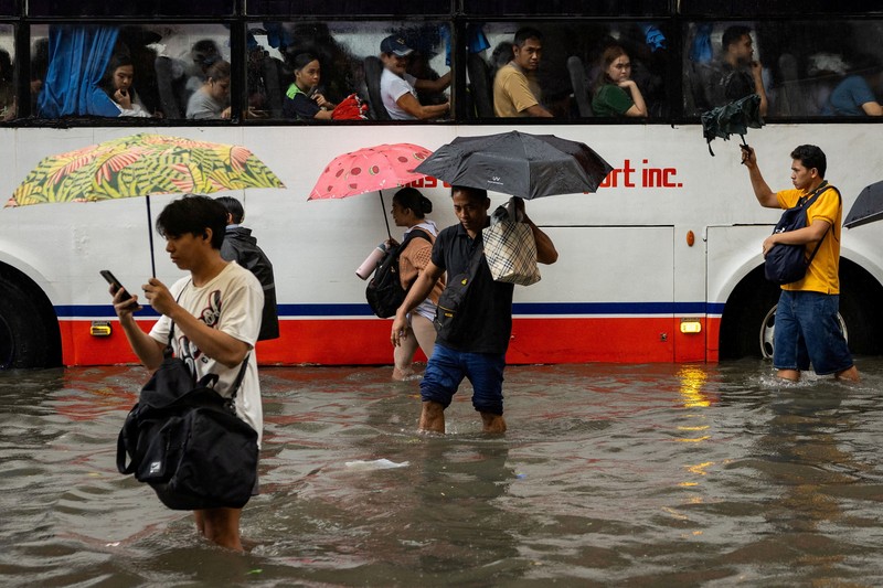 Warga menerjang banjir saat hujan deras musim monsun di Kota Manila, Filipina, Senin (17/8/2026). (REUTERS/Eloisa Lopez)
