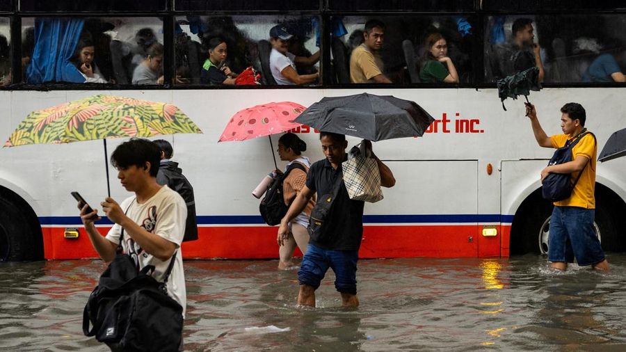 Warga menerjang banjir saat hujan deras musim monsun di Kota Manila, Filipina, Senin (17/8/2026). (REUTERS/Eloisa Lopez)