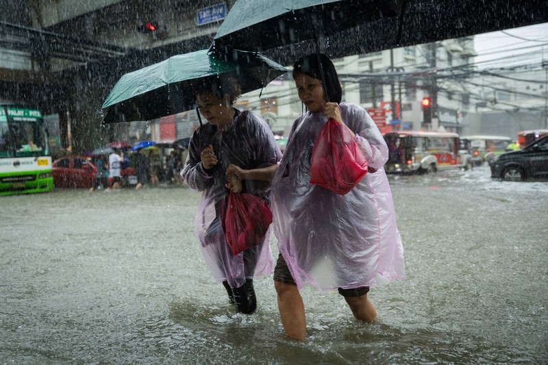 Warga menerjang banjir saat hujan deras musim monsun di Kota Manila, Filipina, Senin (17/8/2026). (REUTERS/Eloisa Lopez)