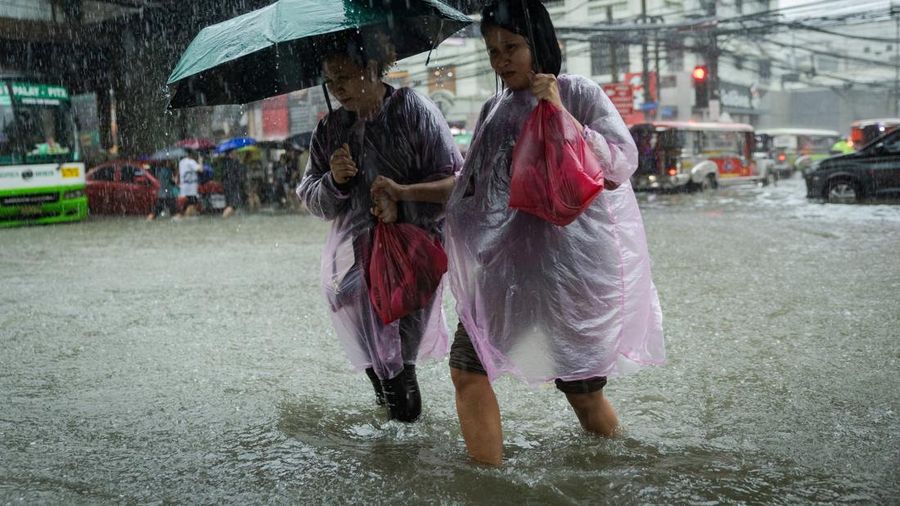 Warga menerjang banjir saat hujan deras musim monsun di Kota Manila, Filipina, Senin (17/8/2026). (REUTERS/Eloisa Lopez)