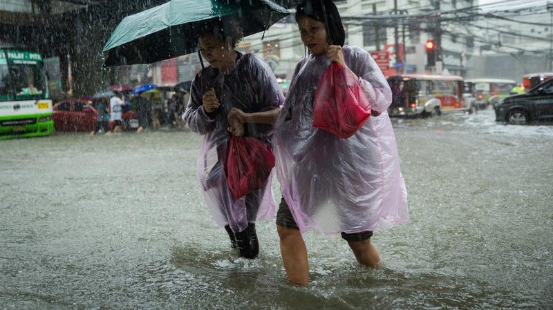 Warga menerjang banjir saat hujan deras musim monsun di Kota Manila, Filipina, Senin (17/8/2026). (REUTERS/Eloisa Lopez)
