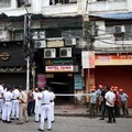 Firefighters and other officials stand on the street in the aftermath of a hotel fire that killed several people in Kolkata, India, August 19, 2026. REUTERS/Sahiba Chawdhary
