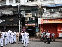 Firefighters and other officials stand on the street in the aftermath of a hotel fire that killed several people in Kolkata, India, August 19, 2026. REUTERS/Sahiba Chawdhary