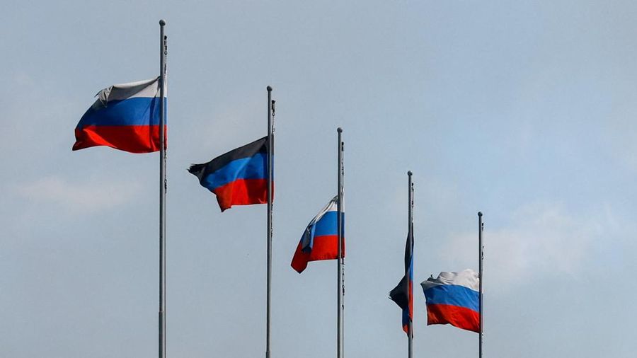 Flags fly outside a burnt-out hypermarket following an overnight attack, what Russian-installed authorities called a Ukrainian drone strike, in the course of the Russia-Ukraine conflict in Makiivka (Makeyevka) in the Donetsk region, a Russian control