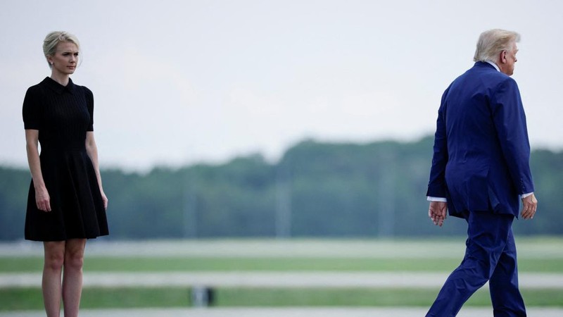 U.S. President Trump walks by his Executive assistant Natalie Harp as they attend a dignified transfer of the remains of U.S. Army service members, Army 1st Lt Tyler James Feehan, Sgt. Angel S. Rampersad, Pvt. Isabella Gonzales, killed during an atta