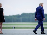 U.S. President Trump walks by his Executive assistant Natalie Harp as they attend a dignified transfer of the remains of U.S. Army service members, Army 1st Lt Tyler James Feehan, Sgt. Angel S. Rampersad, Pvt. Isabella Gonzales, killed during an atta