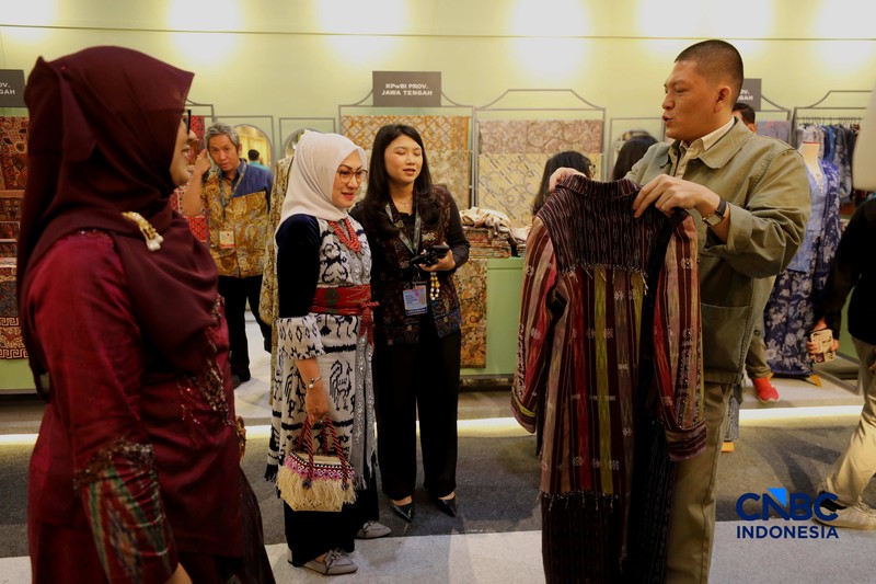 Pengujung mengamati batik yang di pamerkan dalam acara Karya Kreatif Indonesia 2026 di JICC, Jakarta, Kamis (20/8/2026). (CNBC Indonesia/Tri Susilo)