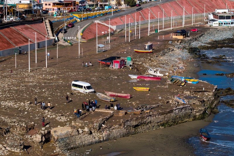 Sebuah tayangan dari drone memperlihatkan orang-orang sedang memindahkan perahu dan kendaraan setelah hujan deras dan banjir memicu tanah longsor di Coloso, Chili, pada 19 Agustus 2026. (REUTERS/Cristian Rudolffi)