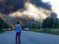Seorang warga melihat gudang makanan yang terbakar setelah terkena serangan rudal Rusia di tengah serangan Rusia terhadap Ukraina, di wilayah Kyiv, Ukraina, pada 20 Agustus 2026. (REUTERS/Valentyn Ogirenko)