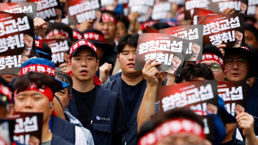 Anggota Serikat Pekerja Logam Korea memegang plakat yang menuntut perundingan bersama secara langsung dengan kontraktor utama dalam sebuah unjuk rasa di luar kantor pusat Hyundai Motor Company, saat serikat pekerja perusahaan otomotif tersebut menggelar pemogokan kerja total pertamanya dalam satu dekade terakhir, di Seoul, Korea Selatan, pada 21 Agustus 2026.