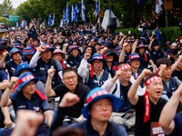 Anggota Serikat Pekerja Logam Korea meneriakkan slogan dan mengangkat kepalan tangan dalam unjuk rasa di luar kantor pusat Hyundai Motor Company saat serikat pekerja perusahaan otomotif tersebut menggelar pemogokan kerja total pertama dalam satu deka