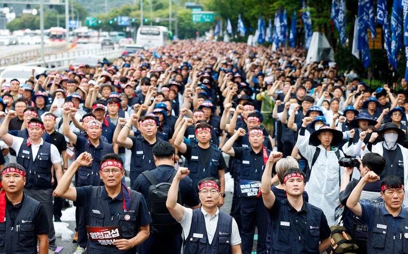 Anggota Serikat Pekerja Logam Korea meneriakkan slogan dan mengangkat kepalan tangan dalam unjuk rasa di luar kantor pusat Hyundai Motor Company saat serikat pekerja perusahaan otomotif tersebut menggelar pemogokan kerja total pertama dalam satu dekade, di Seoul, Korea Selatan, pada 21 Agustus 2026. (REUTERS/Kim Soo-hyeon)