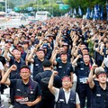 Anggota Serikat Pekerja Logam Korea mengangkat kepalan tangan mereka dalam sebuah unjuk rasa di luar kantor pusat Hyundai Motor Company saat serikat pekerja perusahaan otomotif tersebut menggelar pemogokan kerja total pertamanya dalam satu dekade, di