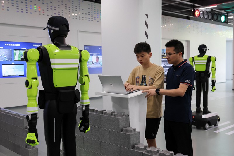 Sebuah robot polisi lalu lintas berbentuk manusia yang dikembangkan oleh SUPCON sedang bertugas di sebuah jalan di Hangzhou, Provinsi Zhejiang, China, pada 21 Juli 2026. (REUTERS/Go Nakamura)