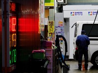 FILE PHOTO: A staff fills up gas in a customer's car at a gasoline station in Tokyo, Japan, March 25, 2026. REUTERS/Kim Kyung-Hoon/File Photo