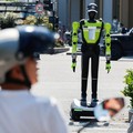 Orang-orang berjalan melewati robot polisi lalu lintas berbentuk manusia yang dikembangkan oleh SUPCON saat robot tersebut sedang bertugas di sebuah jalan di Hangzhou, Provinsi Zhejiang, China, pada 31 Juli 2026. (REUTERS/Go Nakamura)
