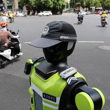 Sebuah robot polisi lalu lintas berbentuk manusia yang dikembangkan oleh SUPCON sedang bertugas di sebuah jalan di Hangzhou, Provinsi Zhejiang, China, pada 21 Juli 2026. (REUTERS/Go Nakamura)