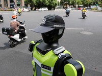 Sebuah robot polisi lalu lintas berbentuk manusia yang dikembangkan oleh SUPCON sedang bertugas di sebuah jalan di Hangzhou, Provinsi Zhejiang, China, pada 21 Juli 2026. (REUTERS/Go Nakamura)
